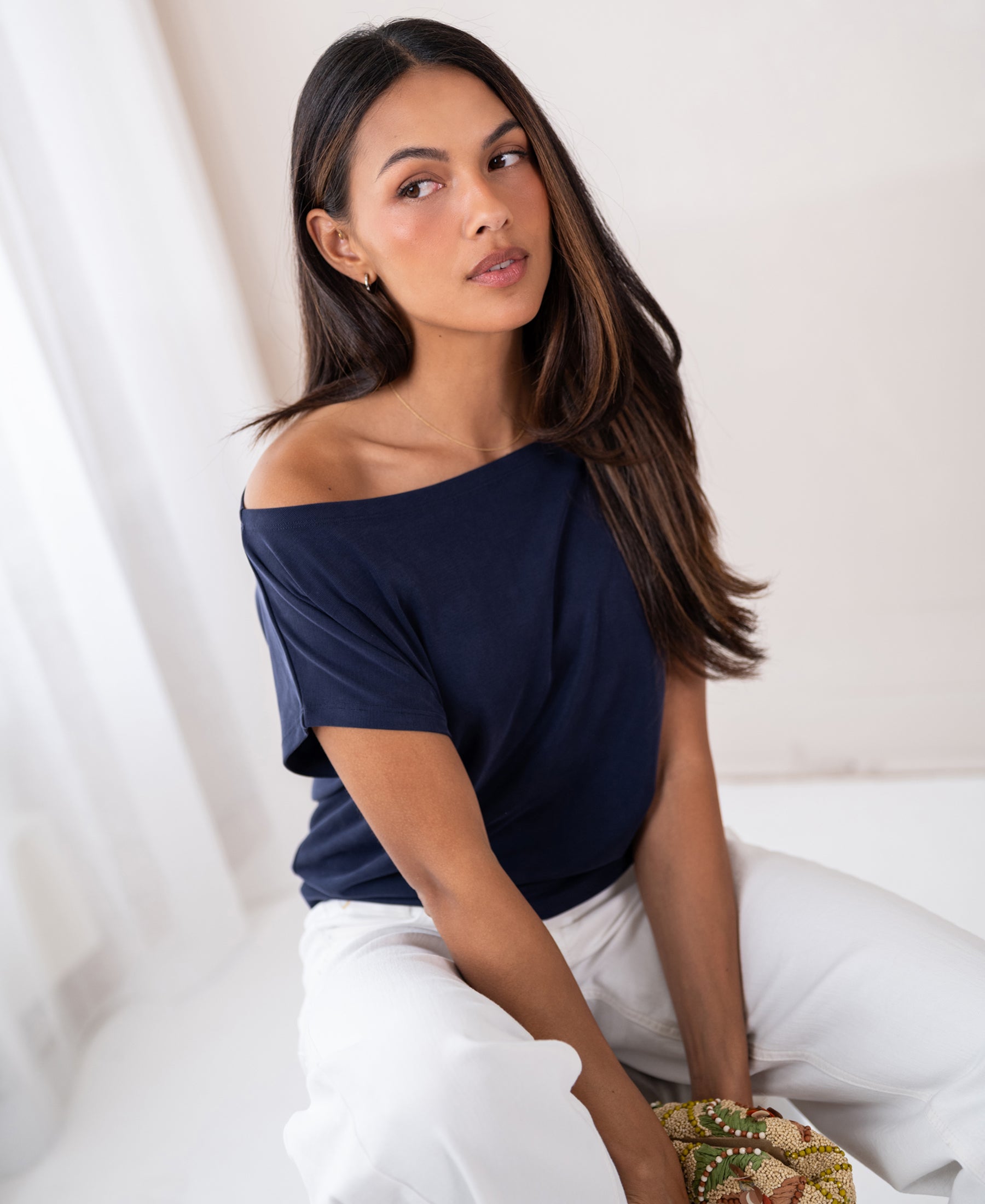 Woman wearing a PLEIN PUBLIQUE ribbed boat neck T-shirt in dark blue (LA SOMME), indoors.