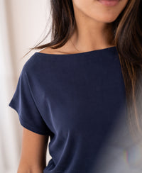 Dark blue ribbed boat neck T-shirt in English, shown from shoulders to lips.