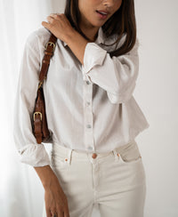 Vrouw draagt de dunne oversized blouse LA SOYEUSE Kit van PLEIN PUBLIQUE in offwhite.