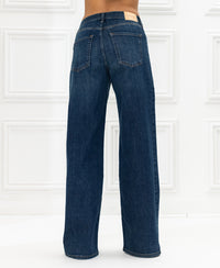 Wide leg blue heritage jeans, shown from the back against white panels.
