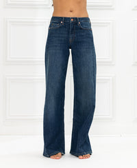 Wide leg jeans in blue heritage, made of organic cotton, shown against a white paneled wall.