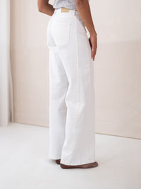 Wide leg jeans LE SPICE White by PLEIN PUBLIQUE, shown from the back in a bright room.