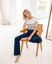 Rinsewash flared jeans by Plein Publique displayed in a bright, minimal room.
