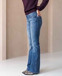 Person wearing stonewash flared jeans indoors.