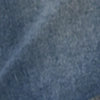 Close-up of blue denim fabric, highlighting its textured weave pattern and subtle lighter streaks.