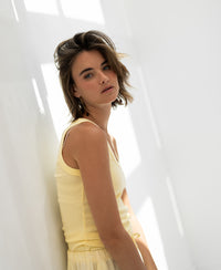 Luxe and soft yellow LA TOULON top by PLEIN PUBLIQUE, shown in natural light against a white wall.