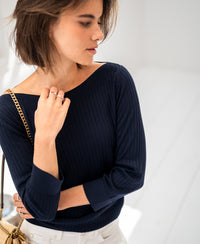 Woman wearing a PLEIN PUBLIQUE Tencel-silk boat neck sweater in dark blue.