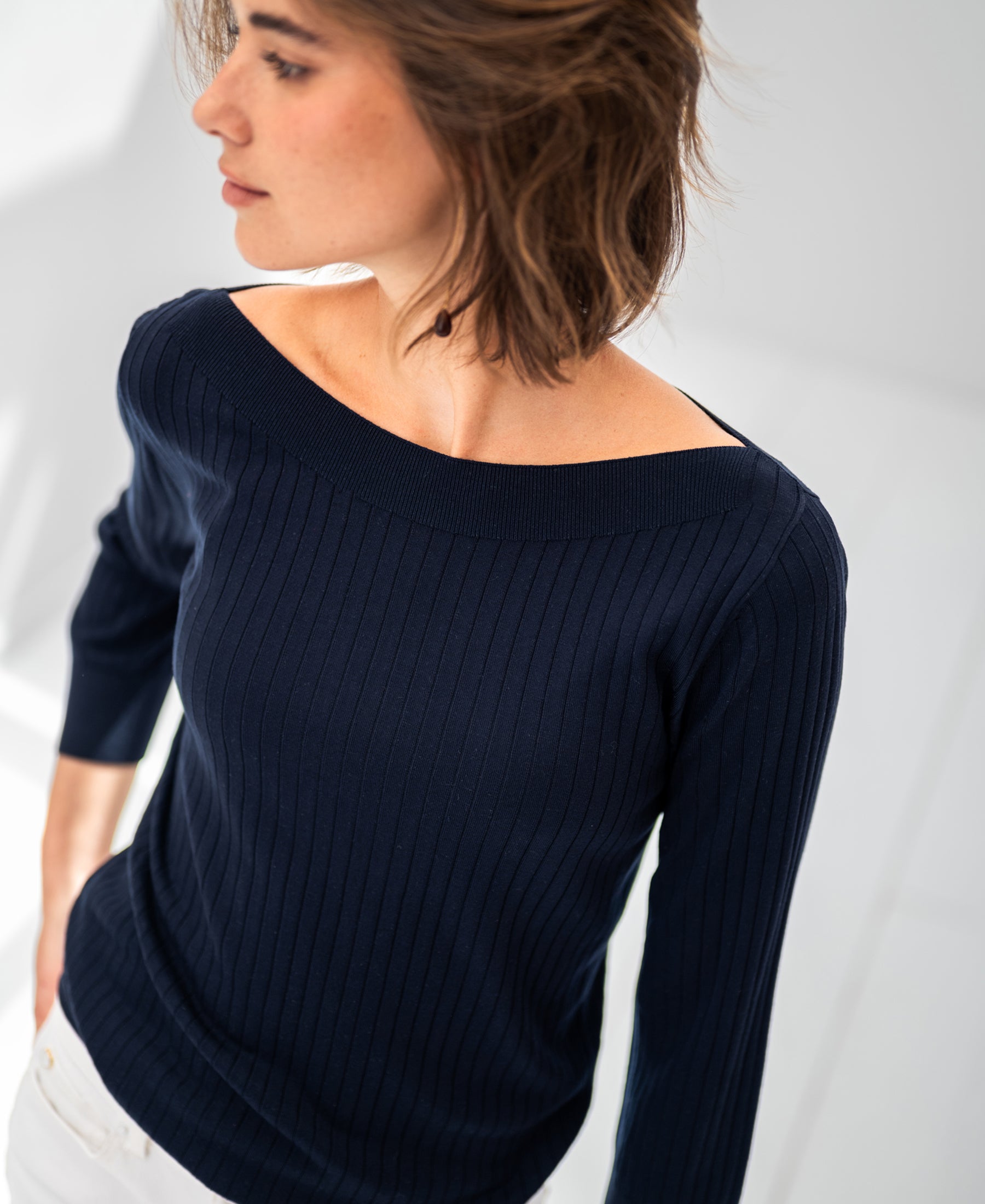 Woman wearing a navy blue PLEIN PUBLIQUE Tencel-silk boat neck sweater LA TULIPE.