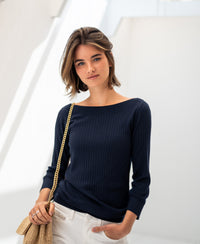 Woman wearing a dark blue Tencel-silk boat neck sweater indoors.