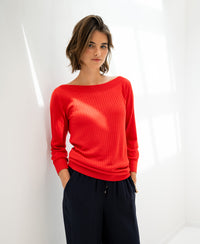Coral red Tencel-silk boat neck sweater by PLEIN PUBLIQUE LA TULIPE, shown against a white wall.