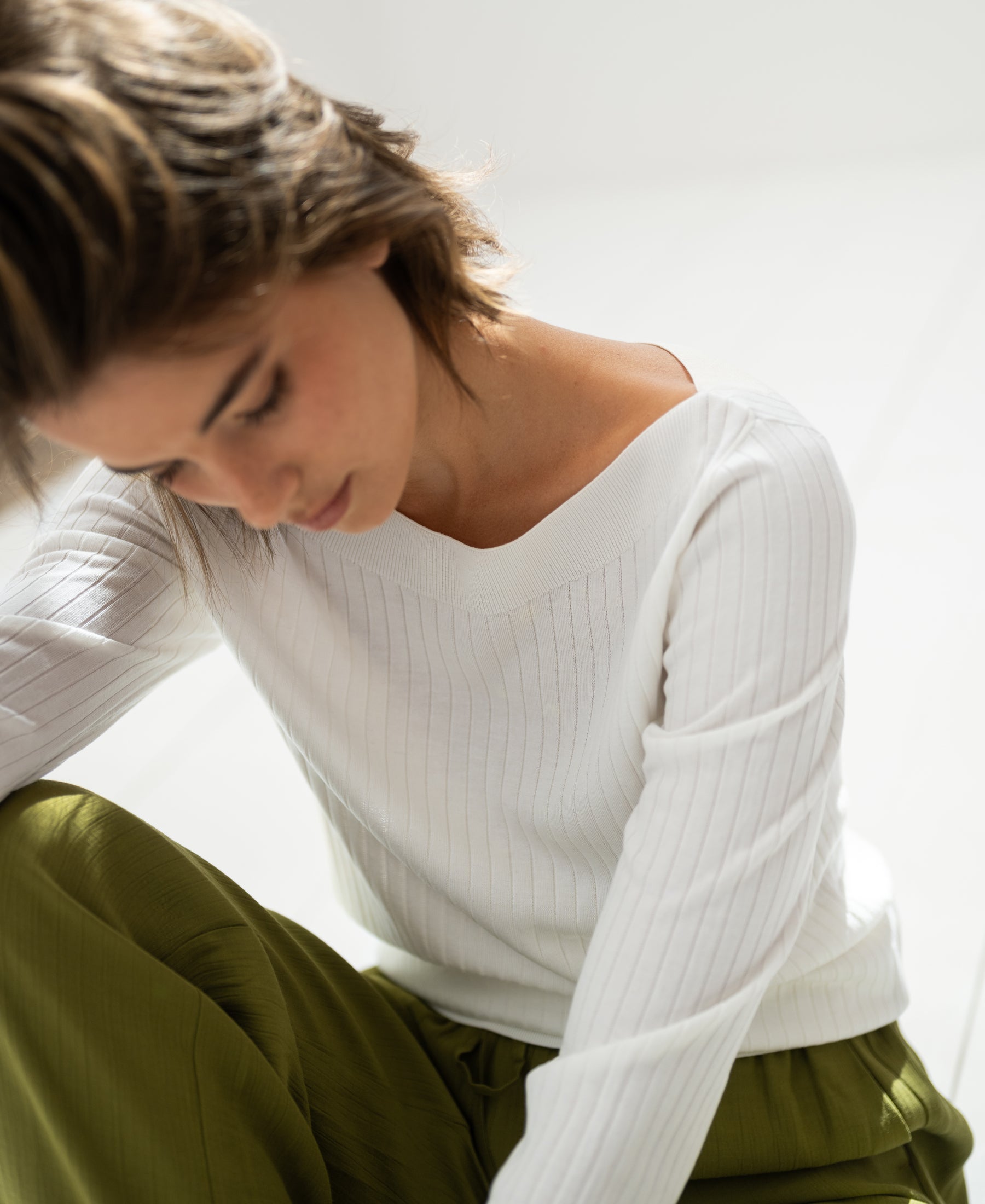 White Tencel-silk boat neck sweater by PLEIN PUBLIQUE softly illuminated by natural light.