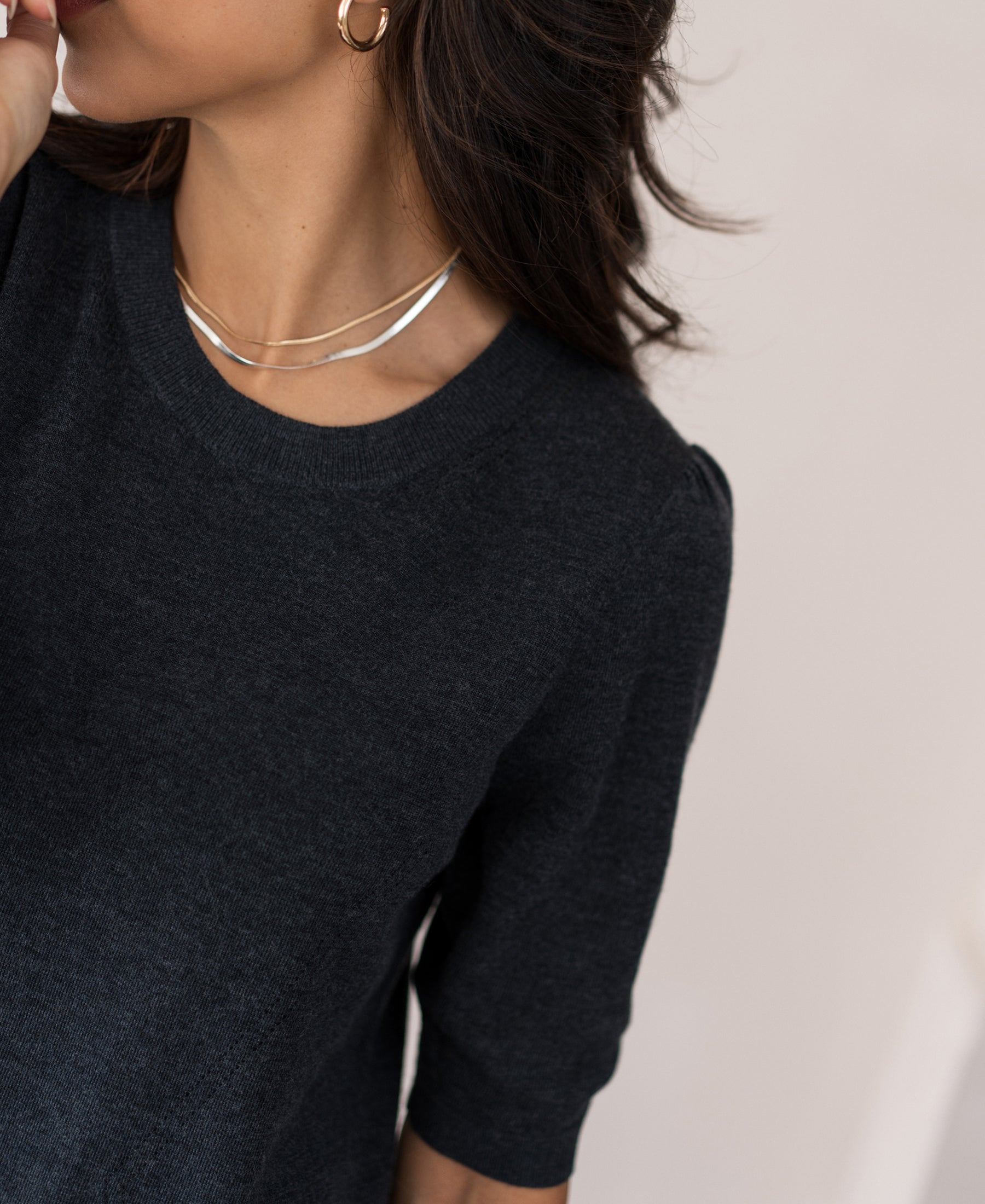 Woman wearing a Plein Publique merino wool dress in anthracite, cropped at the nose.