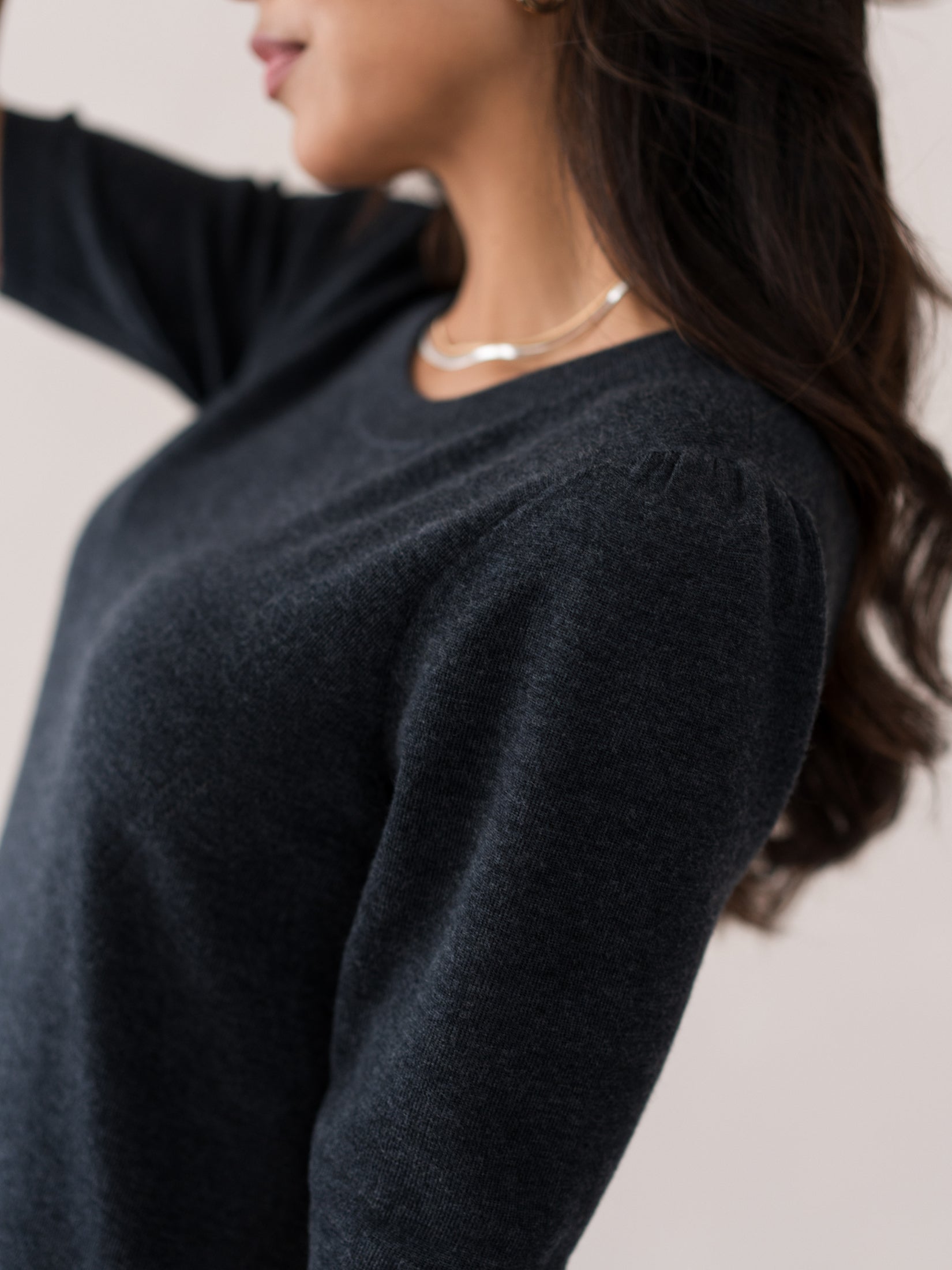 Side view of a woman wearing a PLEIN PUBLIQUE merino wool dress in anthracite.