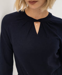 Navy blue PLEIN PUBLIQUE LA TWIST merino wool sweater with keyhole neckline and small chain, shown from shoulders to lips.