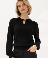 Woman wears the PLEIN PUBLIQUE Merino wool sweater LA TWIST in black.