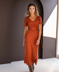 PLEIN PUBLIQUE long dress LA FILICIA in terra color, shown indoors in front of a dark arch, front view.