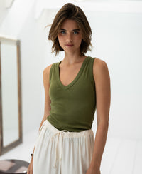 Woman wears the PLEIN PUBLIQUE Luxe & Soft LA VALE top in olive green in a bright room.