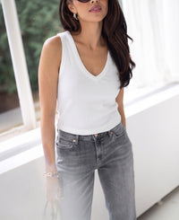 White Luxe & Soft Top by PLEIN PUBLIQUE shown on a woman standing by a sunlit window.