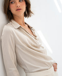 Luxe blouse in light sand by PLEIN PUBLIQUE, shown in soft natural light.