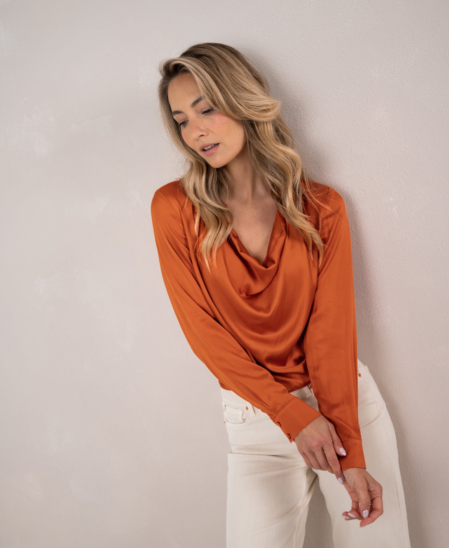 Woman wearing a PLEIN PUBLIQUE satin stretch blouse in Terra color.