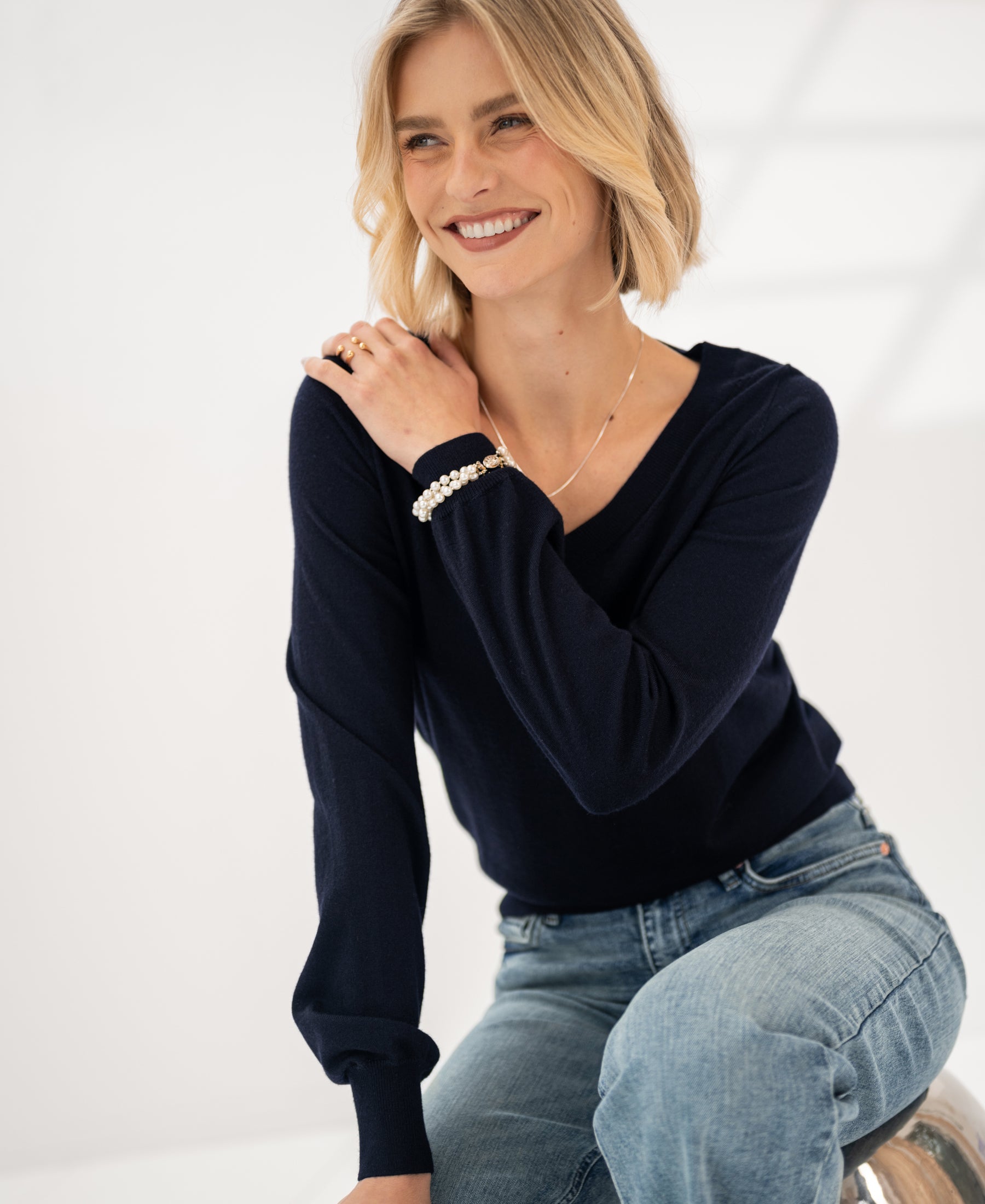 Navy blue PLEIN PUBLIQUE Merino wool V-neck sweater LA VILLE worn by a woman.