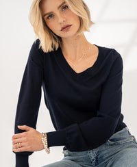 Woman wearing PLEIN PUBLIQUE Merino V-neck sweater LA VILLE dark blue indoors.