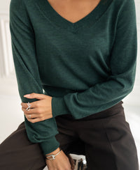 Person wears a PLEIN PUBLIQUE Merino wool V-neck sweater in greenish color.