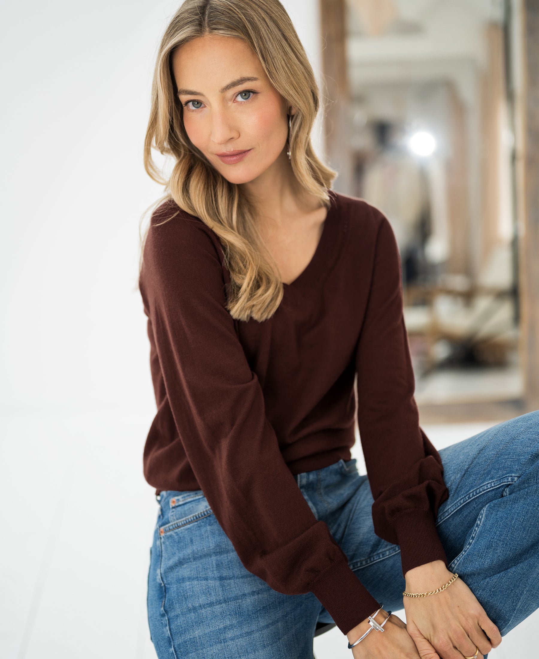 Brown Merino wool V-neck sweater "LA VILLE" by PLEIN PUBLIQUE, shown worn indoors, front view.