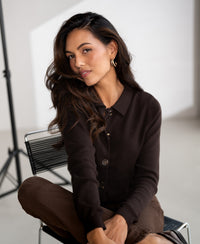 Chocolate brown pure cotton polo collar vest, shown seated and facing the camera.