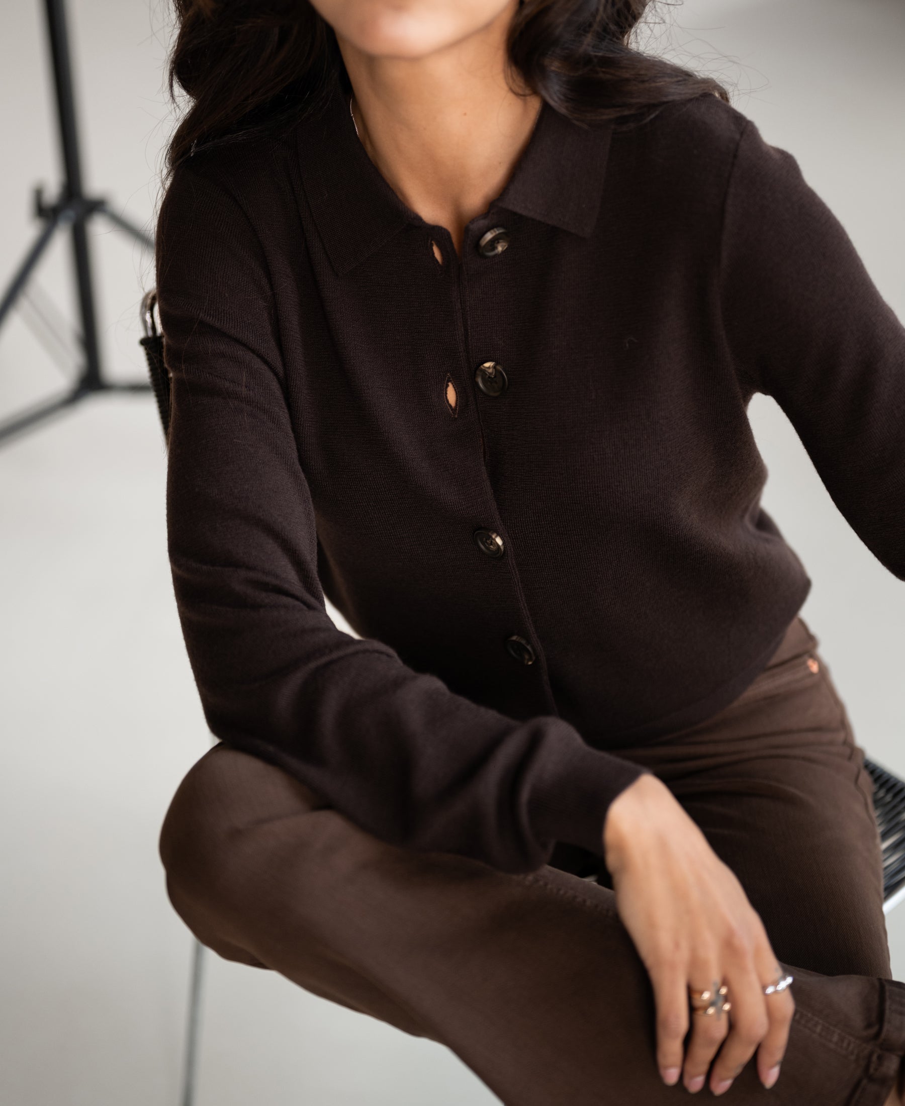 Chocolate brown pure cotton polo collar vest, partially shown on a seated model, face partially out of frame.