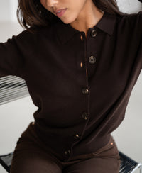 Woman wearing the Plein Publique pure chocolate brown polo collar vest, arms slightly raised.