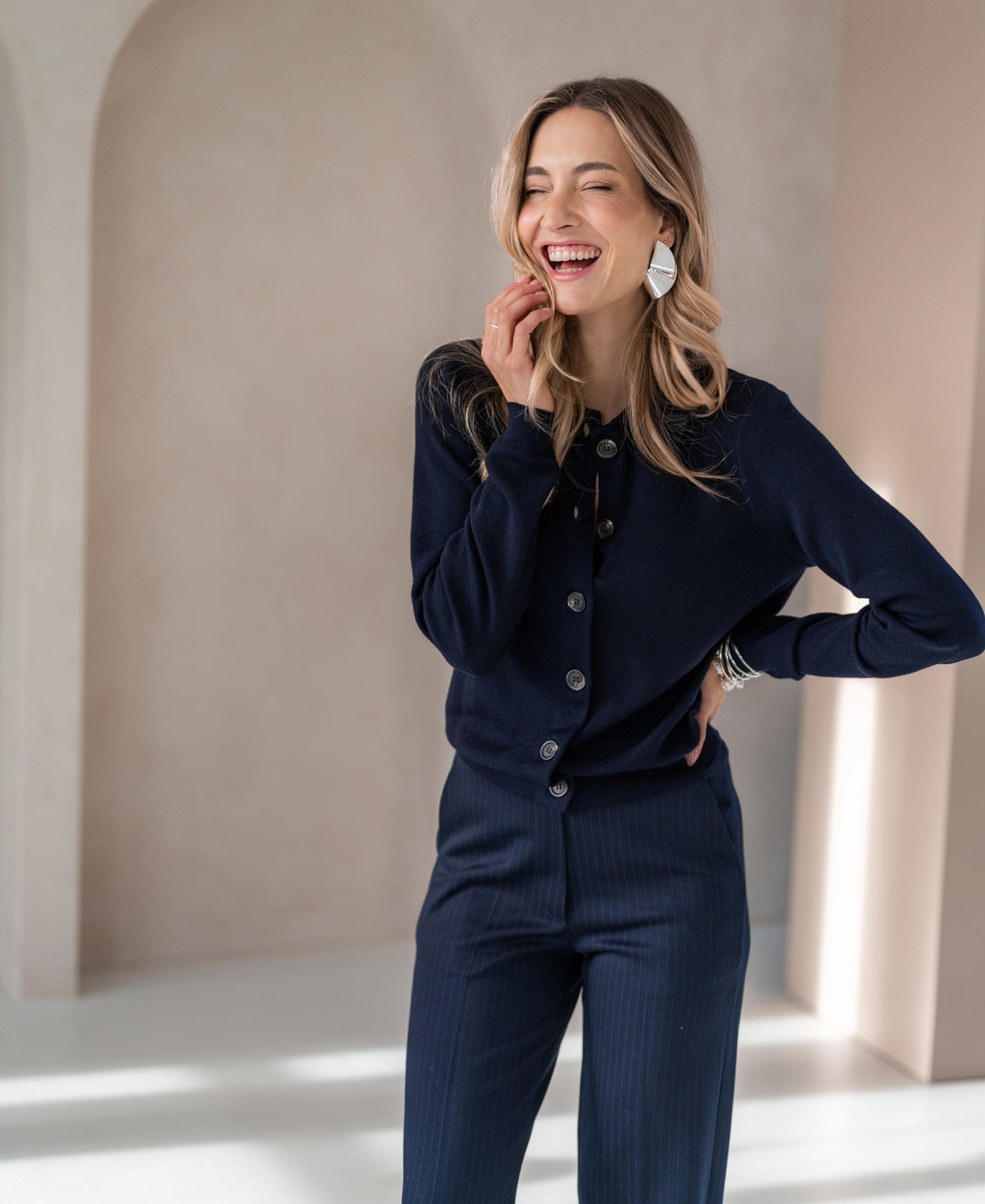 Navy blue PLEIN PUBLIQUE LES VINGT polo-collar cardigan vest shown in a bright room.