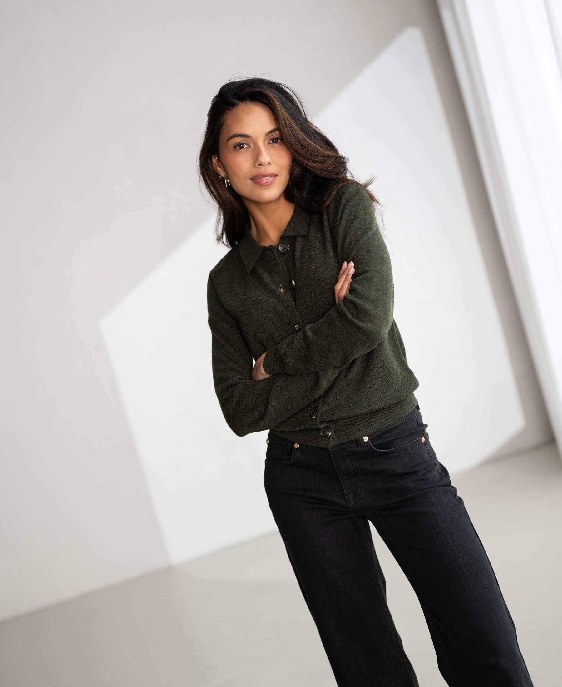 Woman wearing green PLEIN PUBLIQUE polo collar vest, neutral background, soft indoor lighting.