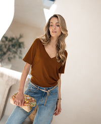 Woman wearing a Havana-colored stretch T-shirt is shown.