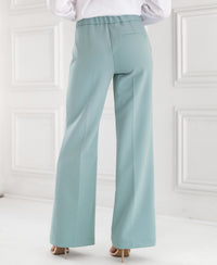 Light blue wide-leg trousers photographed from behind in a bright white room.