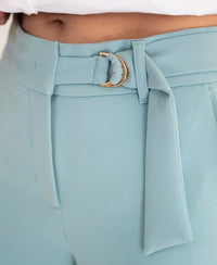 Close-up of elegant PLEIN PUBLIQUE LA WENDE mist blue trousers with a gold buckle.