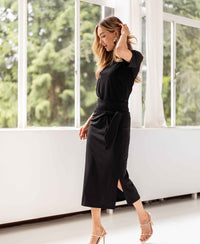 Black travel skirt by PLEIN PUBLIQUE shown indoors near large windows.