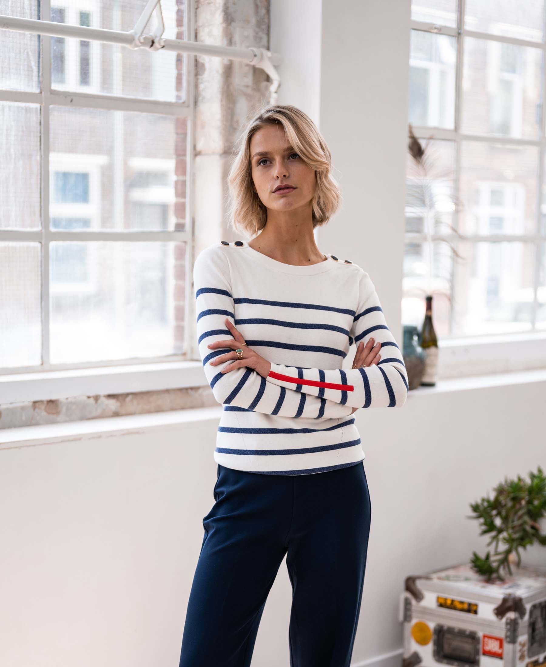 Ivory and denim blue Breton sweater LELISA by PLEIN PUBLIQUE, shown with crossed arms.