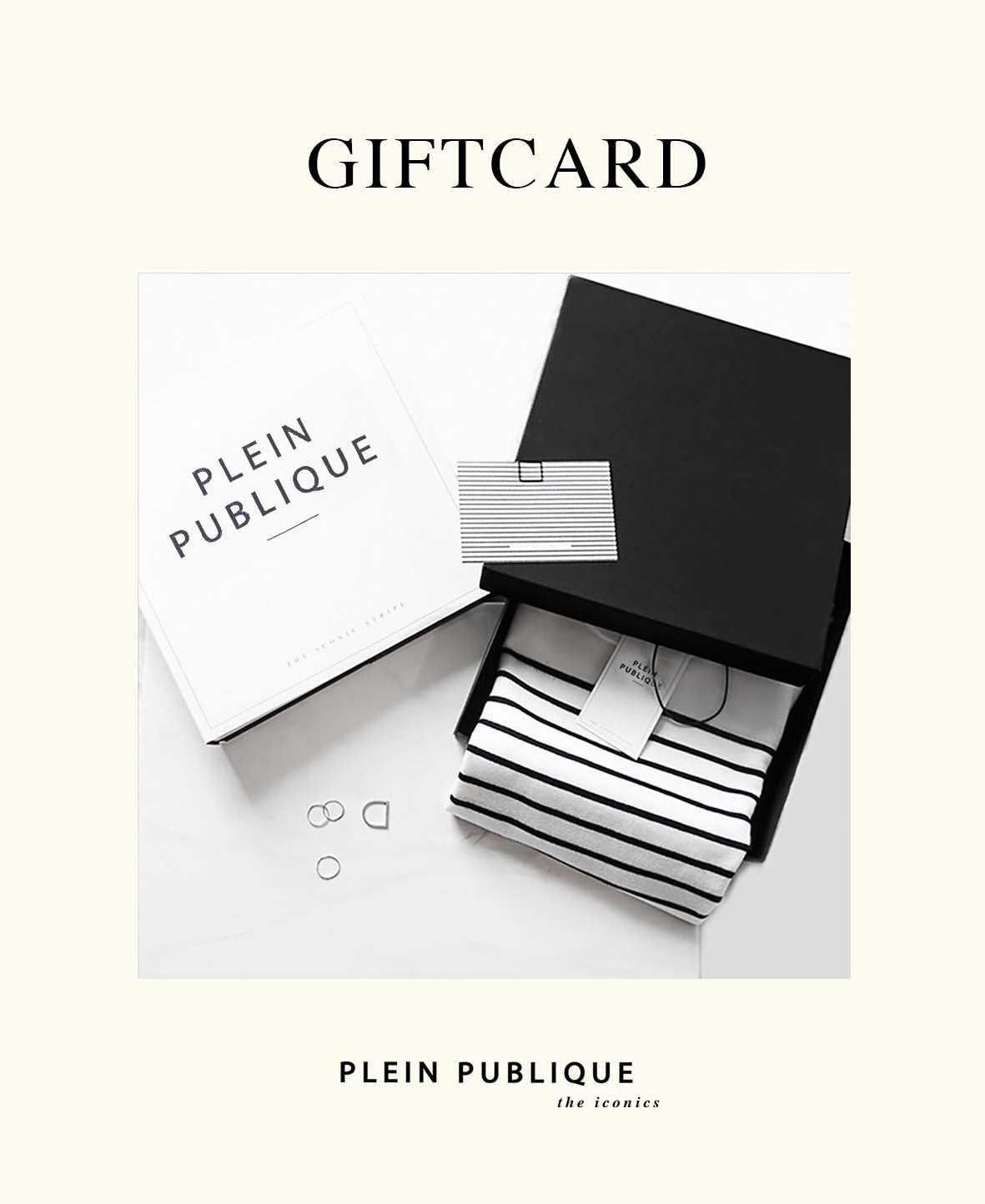 Black gift box with striped shirt and Plein Publique gift card on a white background.