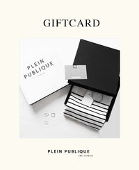 Black gift box with striped shirt and Plein Publique gift card on a white background.