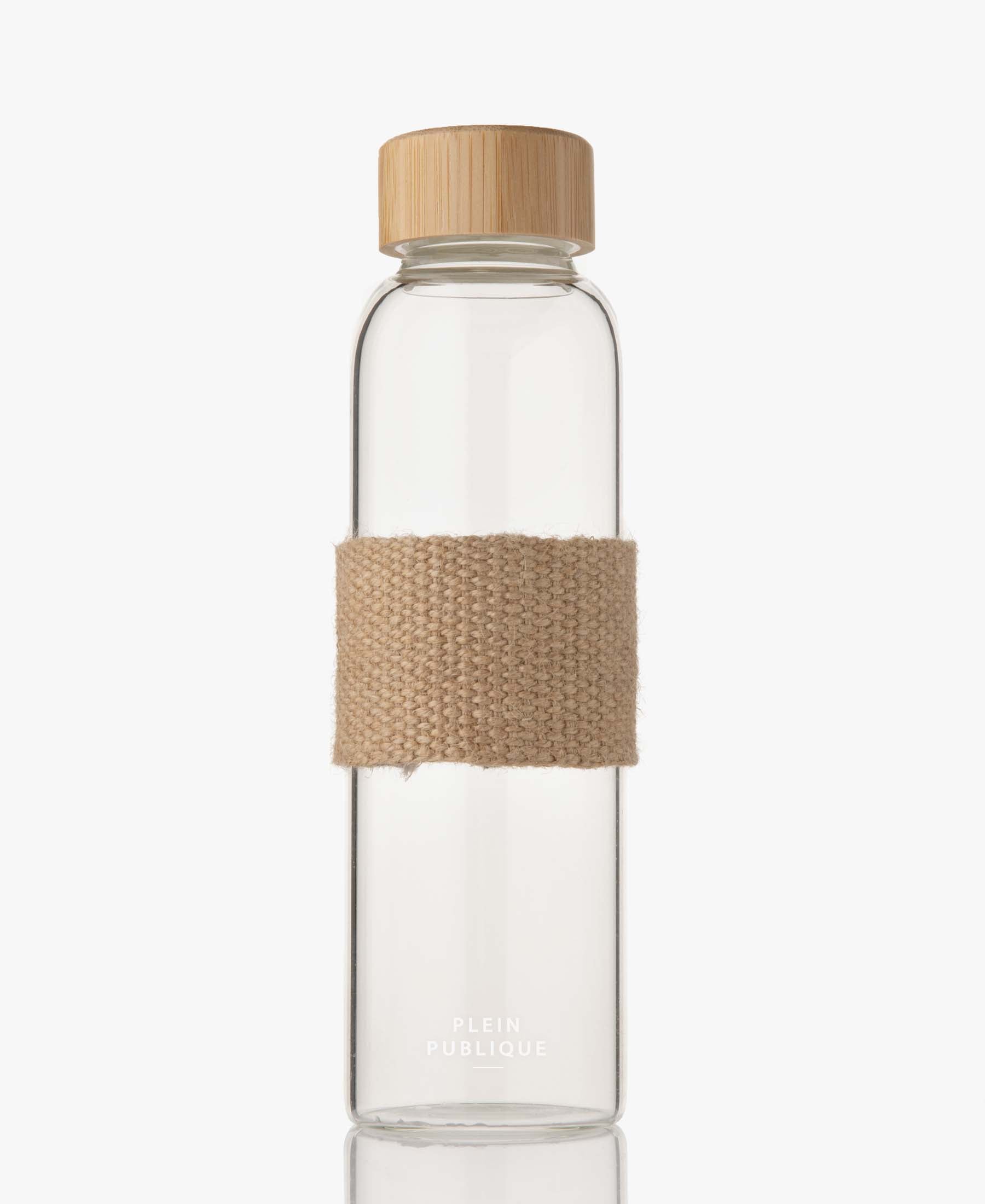 Glass water bottle with bamboo lid from PLEIN PUBLIC, made of durable borosilicate glass with a beige fabric strap.