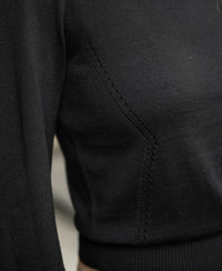Close-up of the black-gold Merino sweater LA CLIQUE by PLEIN PUBLIQUE with fine stitching and subtle balloon sleeves.