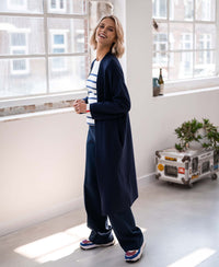 A blonde woman wears a navy Breton sweater in ivory and denim blue from PLEIN PUBLIQUE.