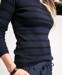 Person wearing navy and black PLEIN PUBLIQUE L'ELISA knit sweater, visible from shoulder to hip.