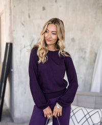 Dark violet LA COEUR sweater by PLEIN PUBLIQUE, shown indoors against a gray textured wall.