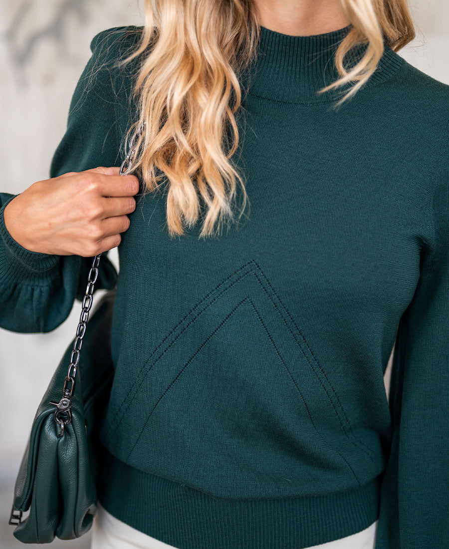 Woman wearing a dark green turtleneck sweater.
