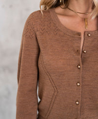 Gold cardigan with openwork details and gold buttons.