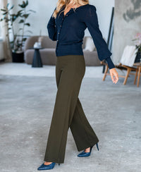 Woman wears the PLEIN PUBLIQUE LA FRAGANCE navy and gold cardigan.